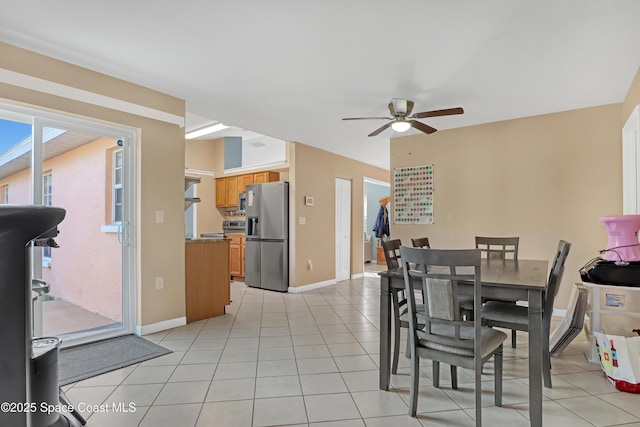 tiled dining space featuring ceiling fan