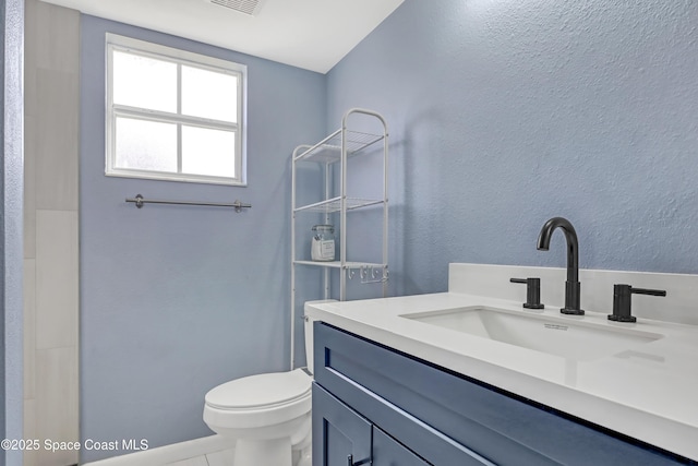 bathroom featuring tile patterned flooring, vanity, and toilet