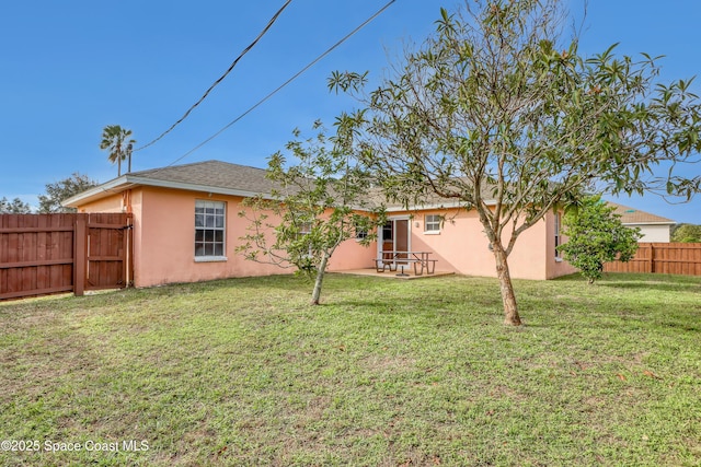 rear view of property featuring a patio area and a lawn