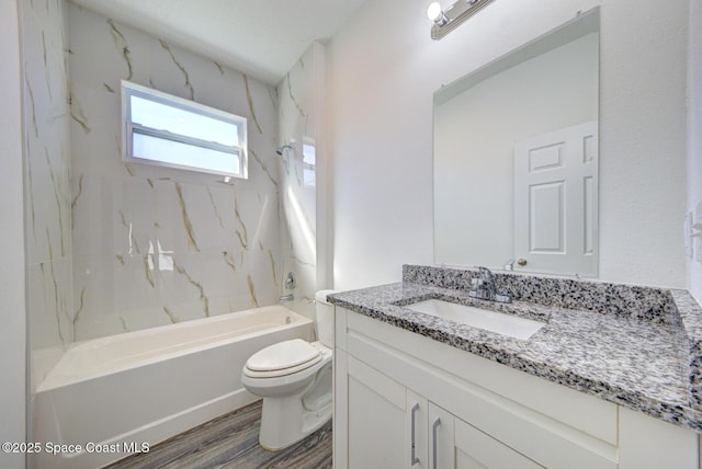 full bathroom with hardwood / wood-style floors, vanity, tiled shower / bath combo, and toilet