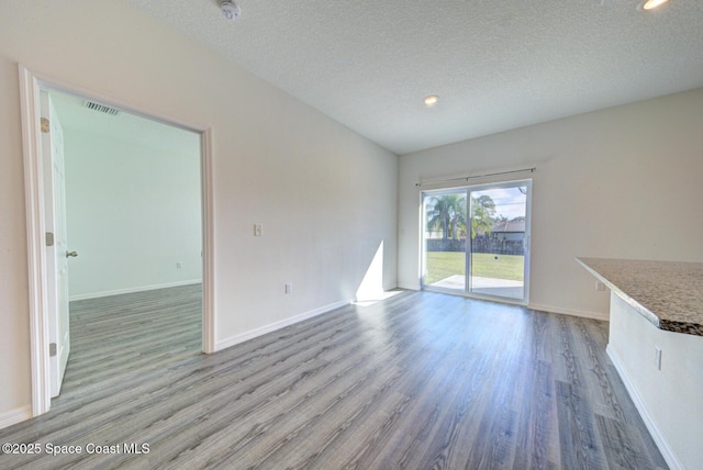 unfurnished living room with wood-type flooring and a textured ceiling