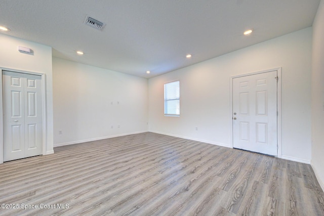 unfurnished room with light wood-type flooring