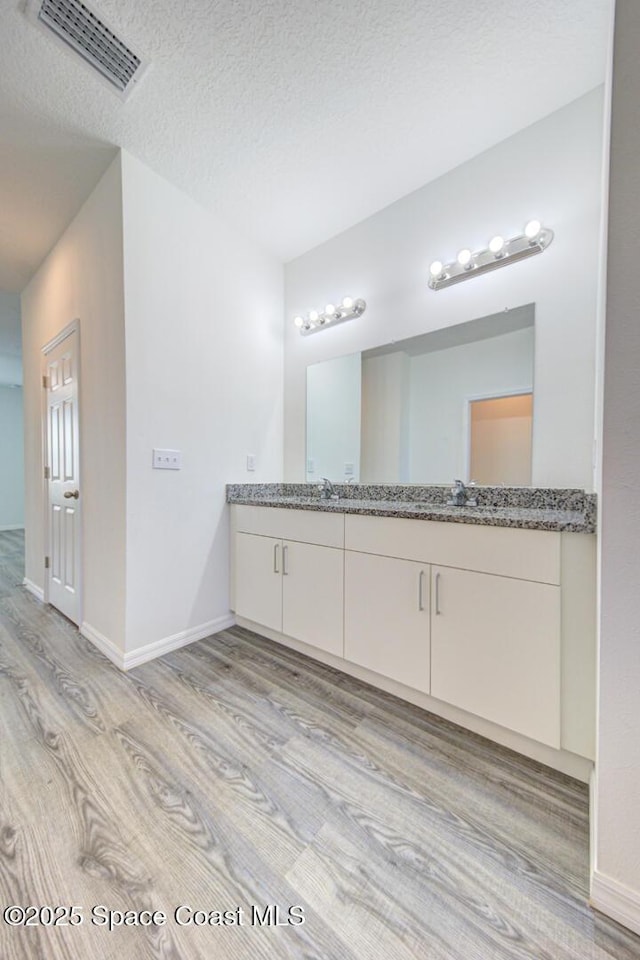 bathroom featuring vanity, a textured ceiling, and hardwood / wood-style flooring