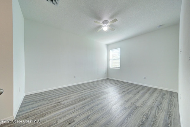 spare room with ceiling fan, light hardwood / wood-style flooring, and a textured ceiling