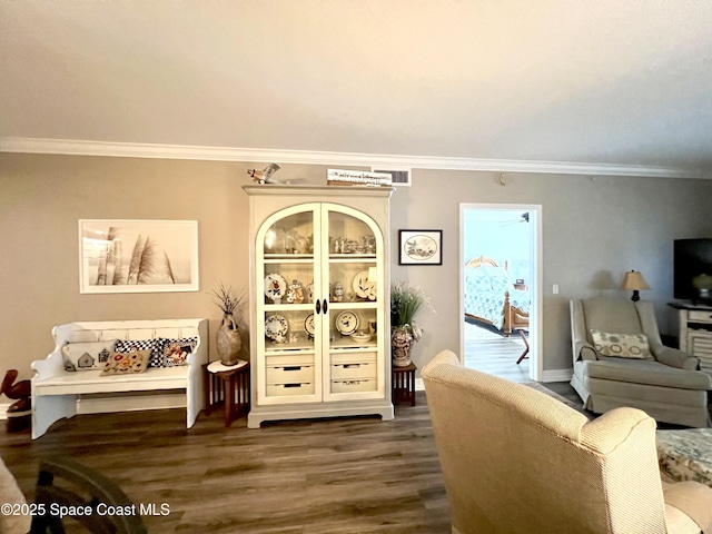 living room featuring dark hardwood / wood-style flooring and crown molding