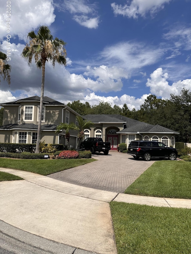 view of front of property featuring a garage and a front lawn