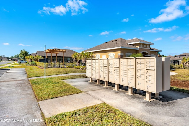 surrounding community with a lawn and a mail area