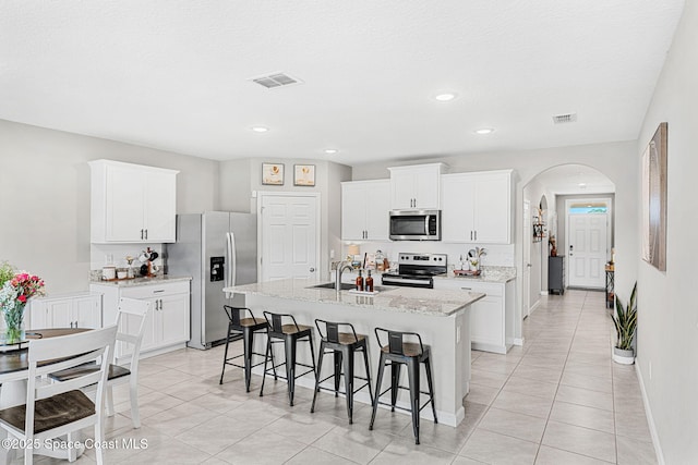 kitchen with white cabinets, sink, a kitchen island with sink, and appliances with stainless steel finishes