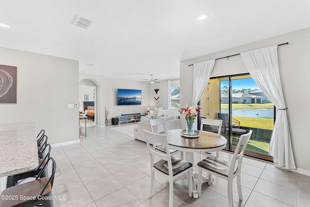 dining space with light tile patterned floors, a textured ceiling, and ceiling fan