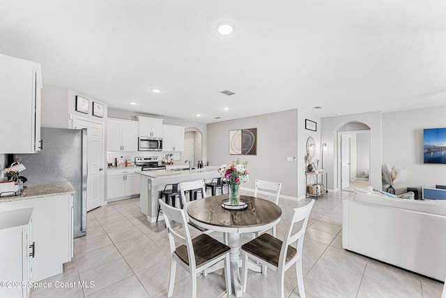 tiled dining area featuring a textured ceiling