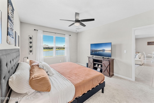 tiled bedroom featuring ceiling fan and a textured ceiling