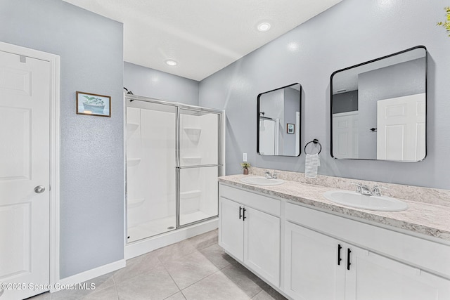 bathroom with tile patterned flooring, vanity, and a shower with door