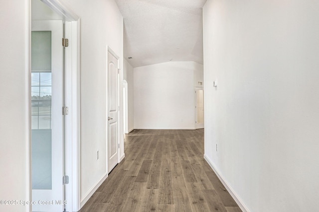 hallway with hardwood / wood-style flooring and lofted ceiling