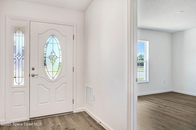 entrance foyer with a textured ceiling and hardwood / wood-style flooring