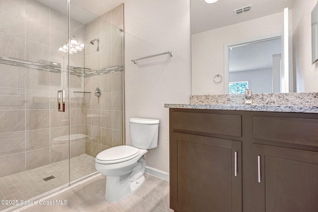 bathroom with tile patterned floors, vanity, toilet, and a shower with door