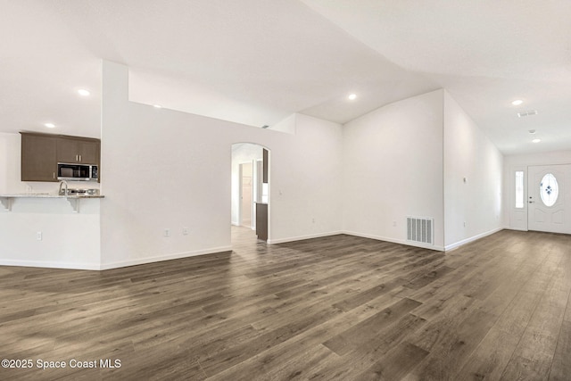 unfurnished living room with dark hardwood / wood-style flooring and lofted ceiling