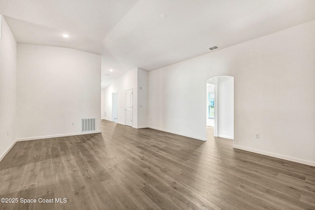 spare room featuring dark hardwood / wood-style floors and vaulted ceiling