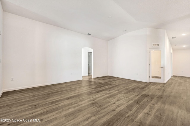 empty room featuring dark hardwood / wood-style flooring and lofted ceiling