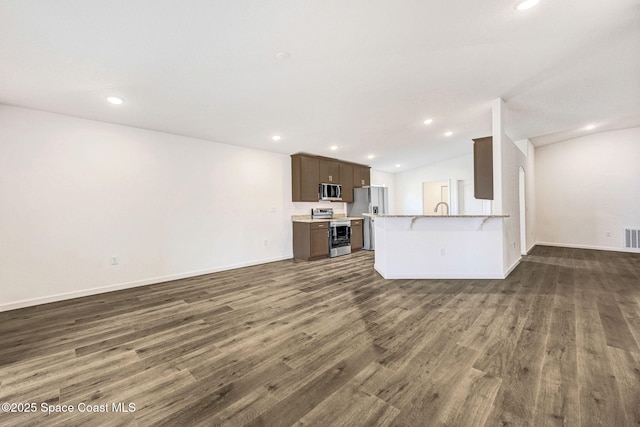 unfurnished living room featuring dark wood-type flooring and vaulted ceiling