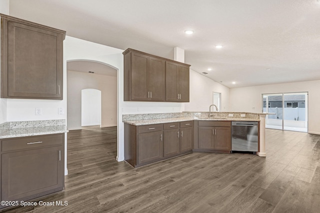 kitchen with kitchen peninsula, sink, stainless steel dishwasher, and dark wood-type flooring