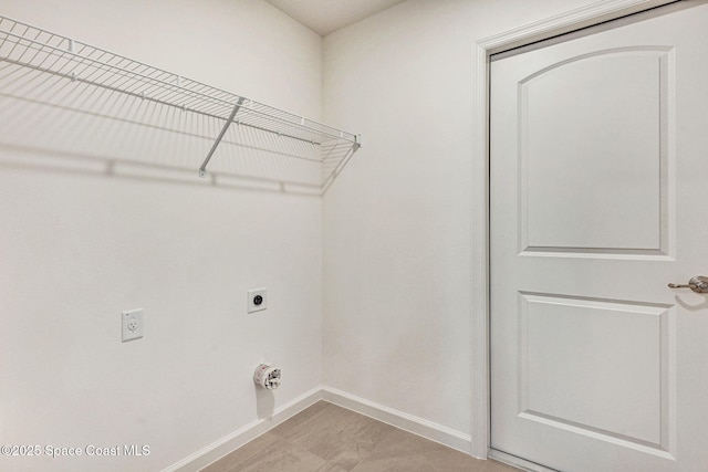 laundry room with hookup for an electric dryer and light tile patterned floors