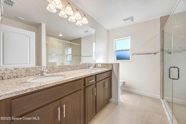 bathroom featuring tile patterned flooring, a textured ceiling, toilet, a shower with door, and vanity