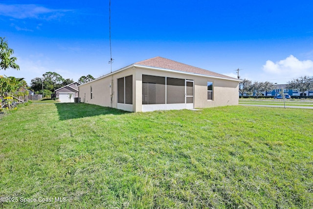 rear view of house with a lawn and a sunroom