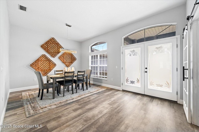 dining space with hardwood / wood-style flooring and a barn door