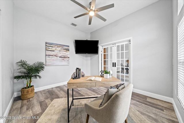 home office with vaulted ceiling, ceiling fan, french doors, and dark hardwood / wood-style floors