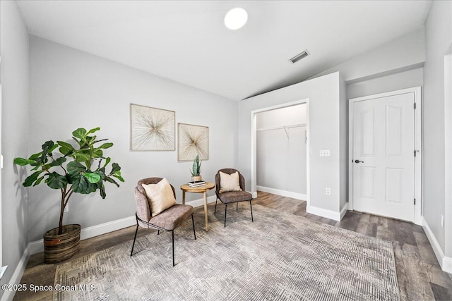 sitting room featuring hardwood / wood-style flooring and vaulted ceiling