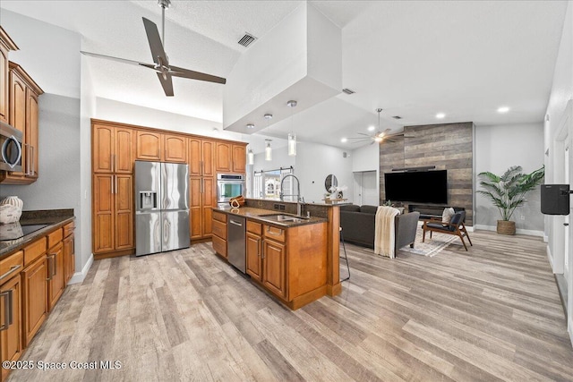 kitchen featuring a kitchen breakfast bar, sink, stainless steel appliances, and vaulted ceiling