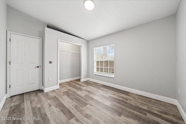 unfurnished bedroom featuring a closet, light hardwood / wood-style flooring, and a textured ceiling