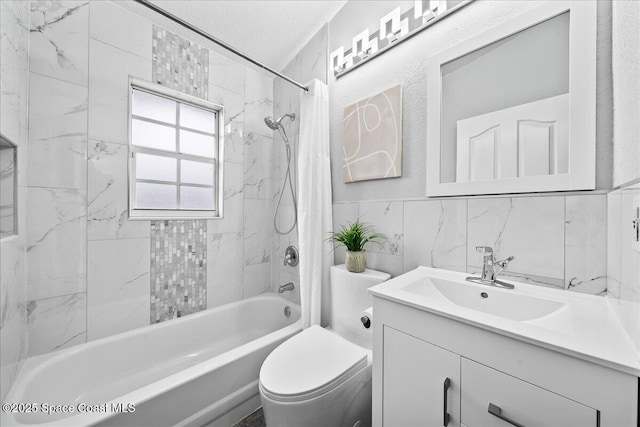 full bathroom featuring vanity, a textured ceiling, tile walls, toilet, and tiled shower / bath