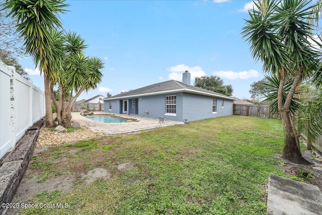 back of house featuring a fenced in pool and a yard