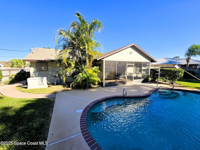 view of pool featuring a sunroom, a yard, and a patio