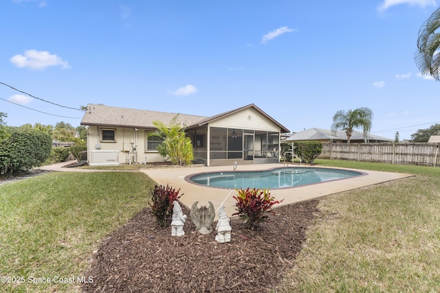 view of swimming pool with a sunroom and a lawn