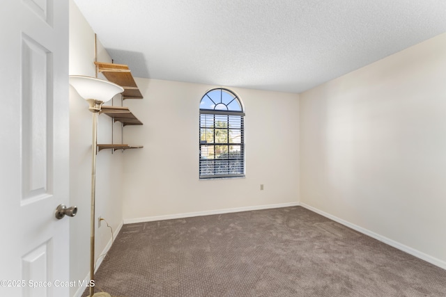 carpeted empty room featuring a textured ceiling