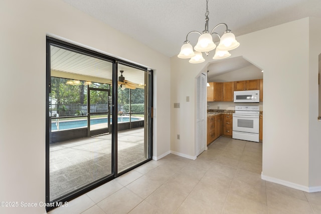 kitchen featuring white appliances, an inviting chandelier, a textured ceiling, light tile patterned flooring, and decorative light fixtures