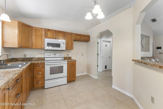 kitchen featuring lofted ceiling, sink, white appliances, light tile patterned flooring, and decorative light fixtures