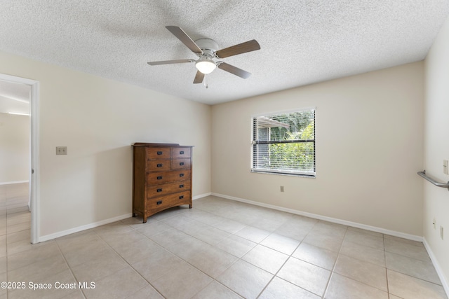 unfurnished bedroom featuring ceiling fan, a textured ceiling, and light tile patterned floors