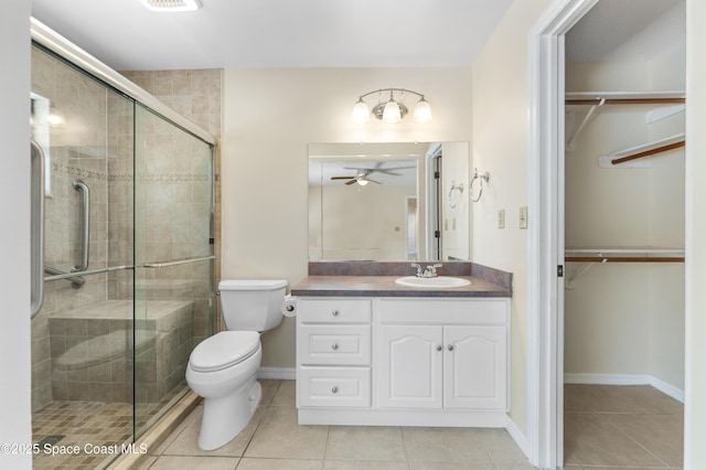 bathroom featuring ceiling fan, tile patterned flooring, vanity, an enclosed shower, and toilet