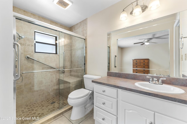 bathroom with toilet, vanity, a shower with door, ceiling fan, and tile patterned flooring