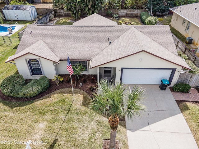 view of front of property featuring central AC, a garage, and a front lawn