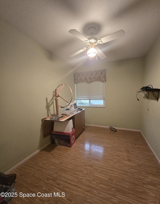 interior space with ceiling fan, dark hardwood / wood-style flooring, and a textured ceiling