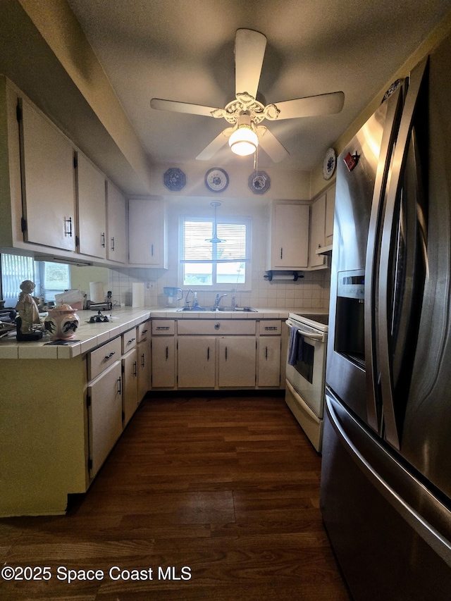 kitchen featuring electric stove, dark hardwood / wood-style floors, stainless steel fridge with ice dispenser, white cabinetry, and sink