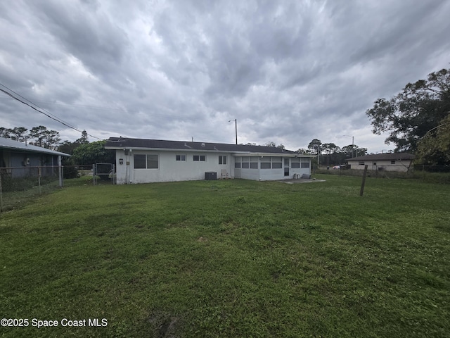 back of property with a yard, cooling unit, and a sunroom