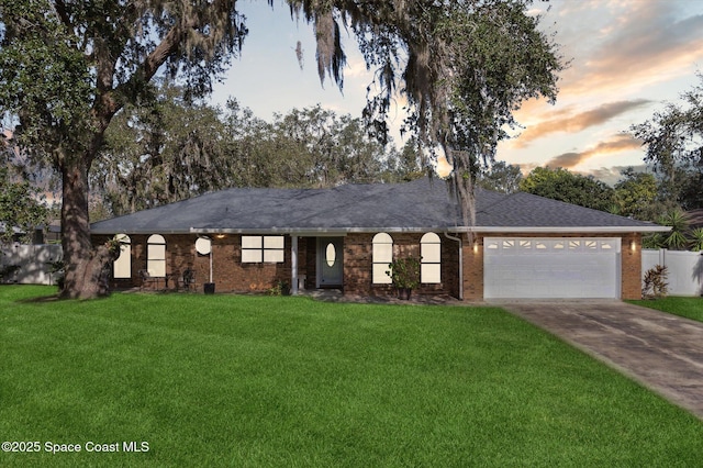 ranch-style home featuring a yard and a garage