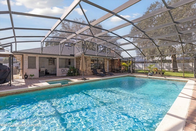 view of swimming pool featuring an in ground hot tub, a patio, and a lanai