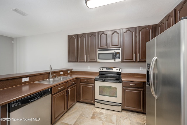 kitchen featuring appliances with stainless steel finishes, sink, and dark brown cabinets