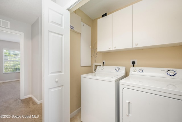 laundry room with independent washer and dryer, light colored carpet, and cabinets